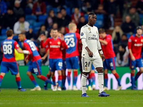Real forward Vinicius Junior walks on the pitch CSKA players celebrate in background their side's third goal.