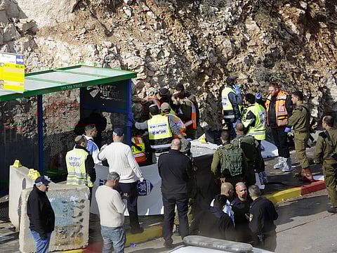 Israeli soldiers and emergency services stand at the scene of an attack near the settlement of Givat Assaf in the West Bank