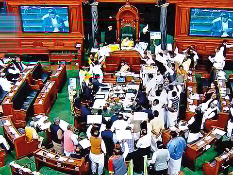 Members protest in the well of the Lok Sabha during the Winter Session of parliament in New Delhi.