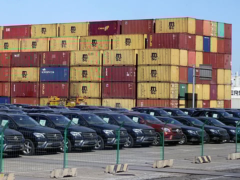 Imported cars are seen next to containers at Tianjin Port, in northern China. 