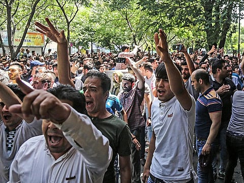 A group of protesters chant slogans at the historic Grand Bazaar in Tehran, Iran, on June 25, 2018. 