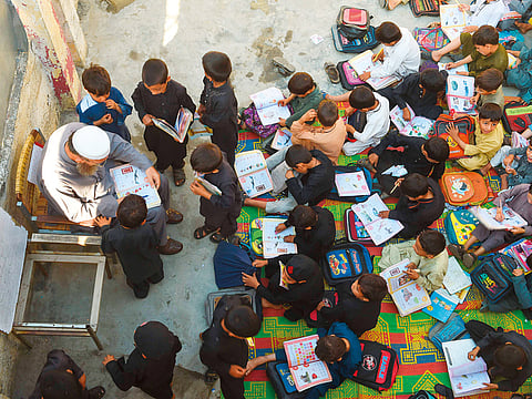 In this picture taken on September 18, 2018, boys attend a class at a school in Mingora, a town in Swat Valley. 