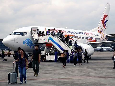 Airline passengers exit a Boeing 737 operated by China Eastern Airlines at Kunming Changshui International Airport in Kunming, Yunnan province, China, on Aug. 21, 2016. 