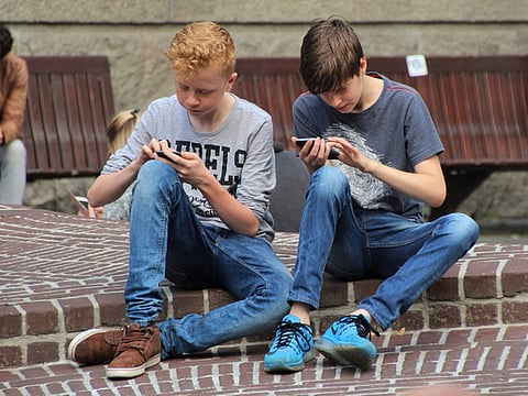 Teenagers playing on their smartphones