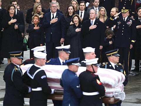 The flag-draped casket of former President George H.W. Bush is carried by a joint services military honor guard