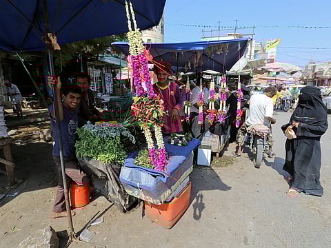 A woman looks at a rose stall on a street in Hodeidah