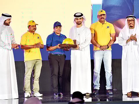 Construction workers present a helmet to Shaikh Mansour at the presentation of Taqdeer awards, a government effort to boost worker productivity and improve labour conditions, in the presence of Maj Genl Bin Surour, and Lieutenant General Dahi Khalfan Tamim.