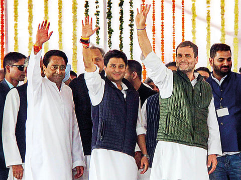 Congress president Rahul Gandhi (right), newly sworn in Madhya Pradesh Chief Minister Kamal Nath (left) and party MP Jyotiraditya Scindia wave at the crowd during the swearing in ceremony in Bhopal.