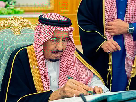 Saudi Arabia's King Salman signing on the 2019 budget following a meeting in Riyadh.