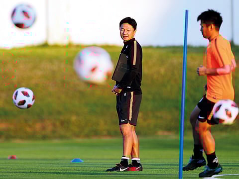 Japan's Kashima Antlers head coach Oiwa Go watches his players warm up during a training session at the Khalifa Bin Zayed stadium in Al Ain.