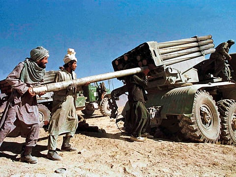 Afghan Taliban fighters load a multiple rocket launcher as they prepare to fire at positions held by the Northern Alliance from a position 25 km north of Kabul in this November 10, 1996 file photograph.