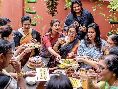 Bharathy Gopalakrishnan, holding glass, during a potluck meal at her home in Kochi, India.