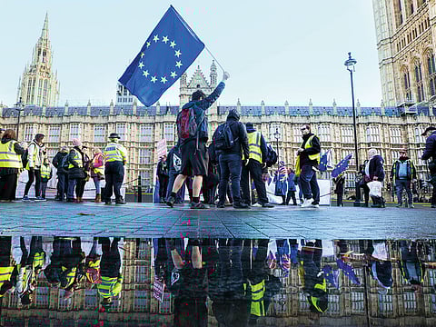 An anti-Brexit demonstrator waves a European Union (EU) flag outside the Houses of Parliament in London, U.K., on Wednesday, Dec. 19, 2018. 