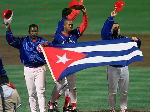In this Monday, May 3, 1999 file photo, members of the Cuban baseball team carry their country's flag onto the field after a baseball game against the Baltimore Orioles at Camden Yards in Baltimore.