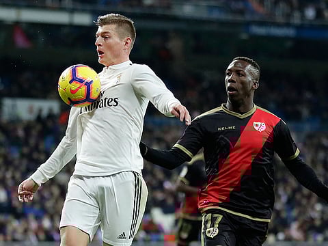 Real Madrid's Toni Kroos, left, duels for the ball with Rayo Vallecano's Luis Advíncula during the Spanish La Liga soccer match between Real Madrid and Rayo Vallecano at the Bernabeu stadium in Madrid, Spain, Saturday, Dec. 15, 2018.