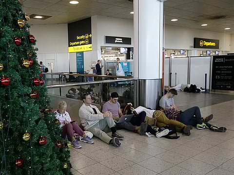 People wait near the departures gate at Gatwick airport, near London, as the airport remains closed with incoming flights delayed or diverted to other airports, after drones were spotted over the airfield last night and this morning, Thursday, Dec. 20, 2018.