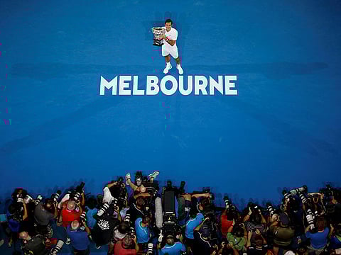 Switzerland's Roger Federer poses with the trophy after winning the final against Croatia's Marin Cilic, January 28, 2018. 