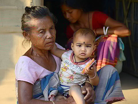 Gunamoni Dalu, 72, holds her granddaughter outside her house at a village near Bamunigaon in Kamrup district in India's northeastern Assam state.