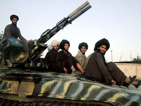 Taliban fighters sit atop a Russian-made tank during a patrol in Kabul, Afghanistan, Tuesday, Oct. 2, 2001.