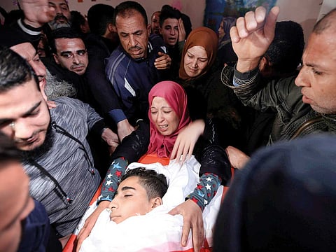 A relative of 16-year-old Mohammad Jahjouh mourns as she looks at his body during his funeral in Gaza City