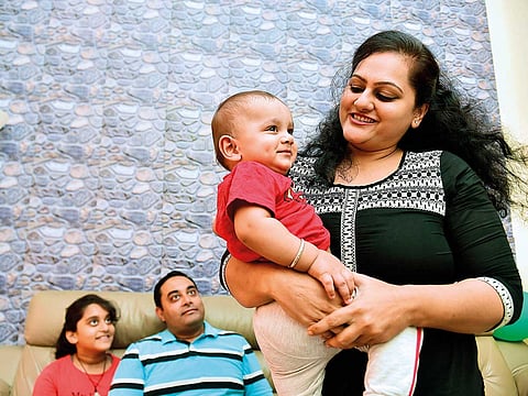 Vanita Saxena proudly holds Vedansh while daughter Vaaruni and husband Shantung look on.