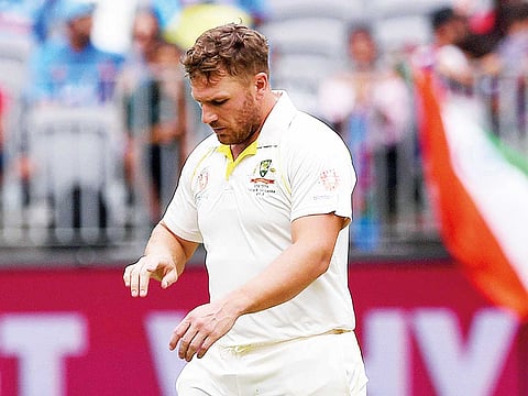 Australia’s Aaron Finch looks at his injured finger before retiring hurt.