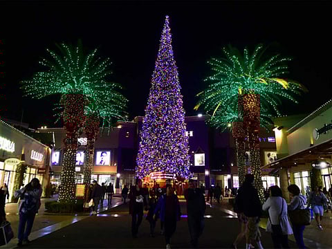 People shop for gifts a week before Christmas at an outlet mall in Commerce, California.