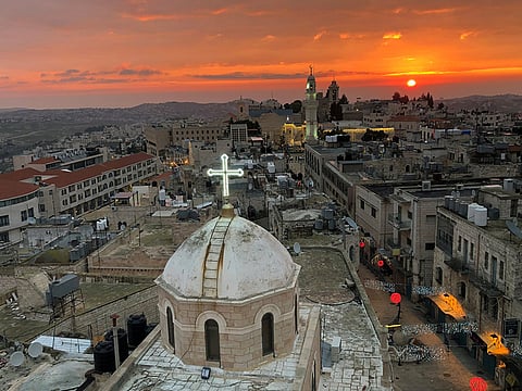 A view shows the dome of the Assyrian church facing a mosque minaret at Manger Square where the Church of the Nativity is located, in Bethlehem 