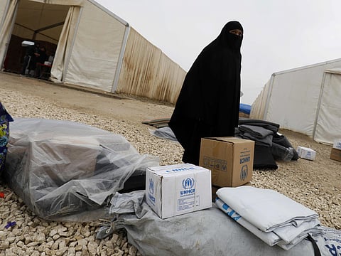 A displaced Syrian woman collects aid provided by the UNHCR (United Nations High Commissioner for Refugees) to set up a tent at the Internally Displaced Persons (IDP) camp of al-Hol in al-Hasakeh governorate in northeastern Syria on December 17, 2018.