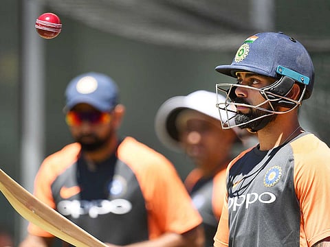 Virat Kohli (R) hits a ball in the air during a training session in Melbourne, ahead of the third cricket Test match against Australia. 