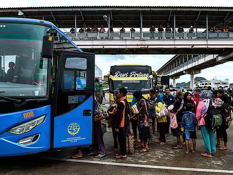 Residents board a bus at the ferry port after being evacuated from Sebesi Island, in Bakauheni in Lampung province.