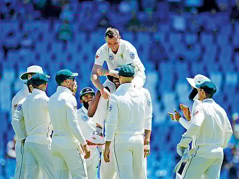 South Africa's Dale Steyn is picked up by teammate Kagiso Rabada as they celebrate after getting Pakistan's Fakhar Zaman's wicket during day one of the 1st cricket test match between South Africa and Pakistan at SuperSport Park cricket stadium on December 26, 2018 in Pretoria. 