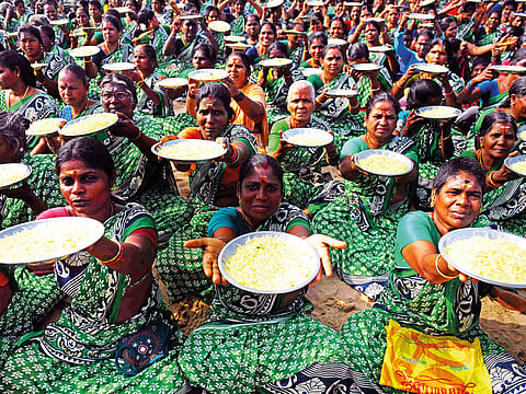 Women hold up plates of flower petals for an offering during a ceremony for the victims of the 2004 tsunami at Pattinapakkam Beach in Chennai, India.