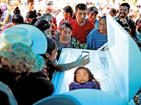 Friends and family gather around the coffin of Jakelin Caal, a 7-year-old girl who handed herself in to U.S. border agents earlier this month and died after developing a high fever while in the custody of U.S. Customs and Border Protection, during her funeral at her home village of San Antonio Secortez, in Guatemala.
