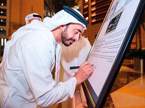 Shaikh Abdullah signs the commemorative stamp and souvenir sheet.