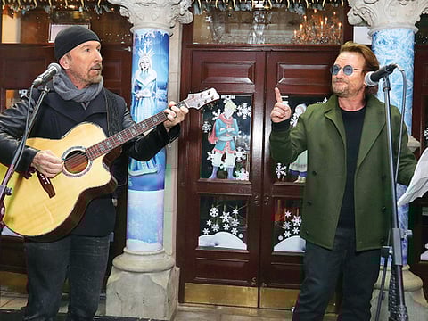 U2’s The Edge and Bono take part in the annual Christmas Eve busk on Grafton Street, Dublin.
