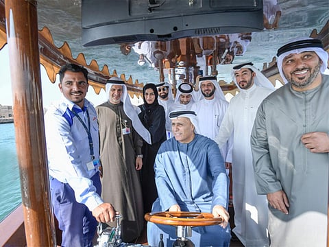 Mattar Al Tayer, Director-General and Chairman of the Board of Executive Directors of RTA, at the helm of the hybrid abra during the test run with other officials.
