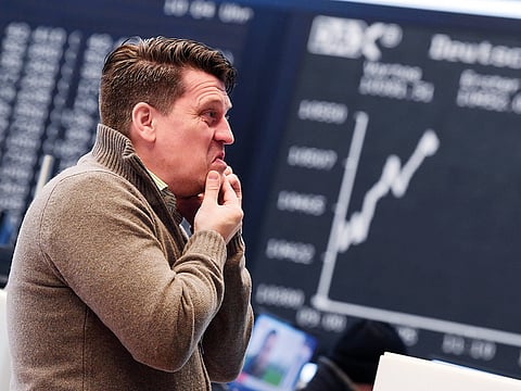 A trader works in front of a board displaying Germany’s DAX index on Friday at the stock exchange in Frankfurt. 