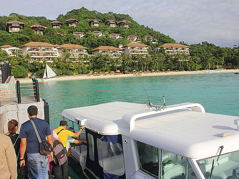 In this file photo taken on January 15, 2018, tourists board a speedboat near a forestland area on Boracay island in Malay town, Aklan province, central Philippines. 