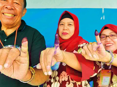 Indonesians show their inked fingers after casting their ballots during regional elections in Tangerang, Banten, during the last elections in 2018.