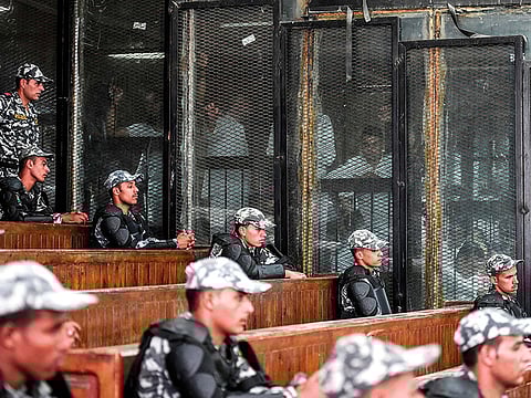 File picture shows members of Egypt's banned Muslim Brotherhood inside a glass dock during their trial in Cairo on July 28, 2018.
