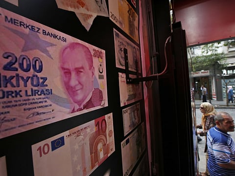 An oversized copy of a 200 Turkish lira banknote, featuring a photo of modern Turkey's founder Mustafa Kemal Ataturk decorates a currency exchange shop in Istanbul, Friday, Aug. 17, 2018. Turkey’s lira fell once again, as Turkey and the United States exchanged new threats of sanctions Friday, keeping alive a diplomatic and financial crisis that is threatening the economic stability of the NATO country. (AP Photo/Lefteris Pitarakis)