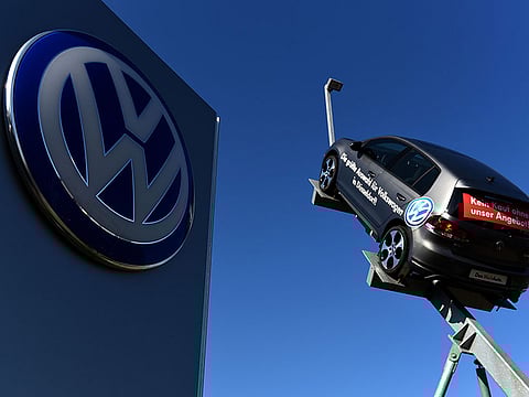 In this file photo taken on September 28, 2015 a model and logo of German car maker Volkswagen (VW) are seen at the entrance to a VW branch in Duesseldorf, western Germany.  