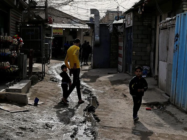 Palestinian refugees walk in a street in the Baladiyat
