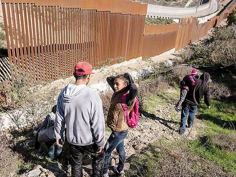 A 17-year-old Honduran migrant talks to her boyfriend before attempting to cross the US-Mexico border fence from Tijuana, Baja California State, Mexico, to the US, on December 30, 2018.