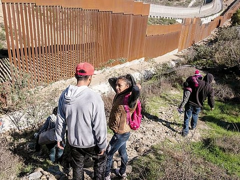 A 17-year-old Honduran migrant talks to her boyfriend before attempting to cross the US-Mexico border fence from Tijuana, Baja California State, Mexico, to the US, on December 30, 2018.