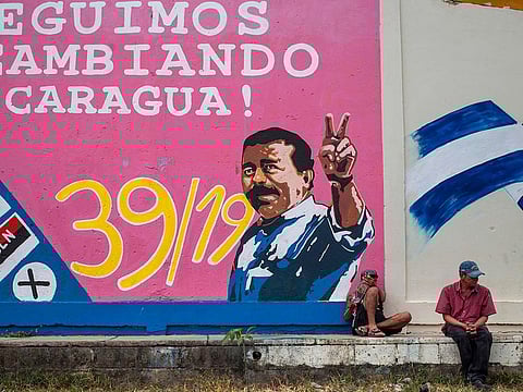 Men rest next to a graffiti of Nicaraguan President Daniel Ortega in Esteli, about 150 km from Managua.