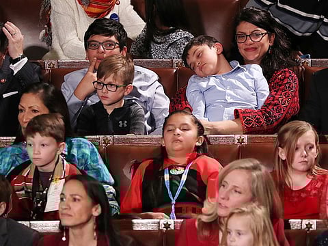 U.S. Representative Rashida Tlaib (TOP R) holds a sleeping child as the U.S. House of Representatives meets for the start of the 116th Congress inside the House Chamber on Capitol Hill in Washington, U.S., January 3, 2019.
