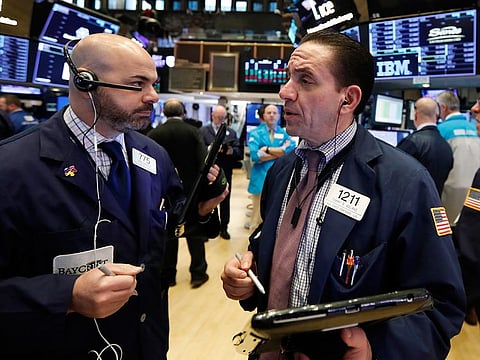 Traders confer as they work on the floor of the New York Stock Exchange, Friday, Jan. 4, 2019. 