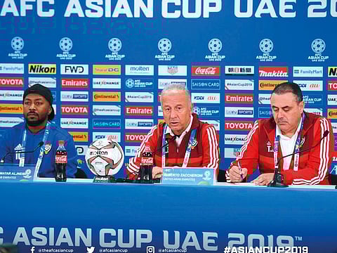 Zaccheroni (centre) interacts with the media ahead of their opening match as Esmail Mattar (left) looks on. 
